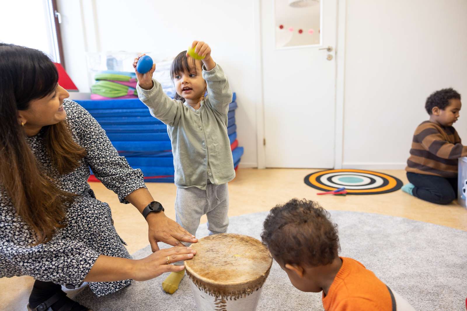 Pedagog leker med små barn i förskolans lekrum